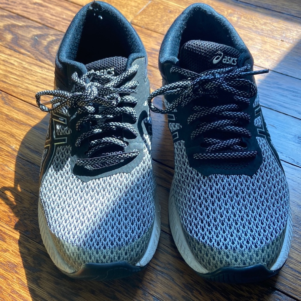 Black and white ASICS tennis shoes.